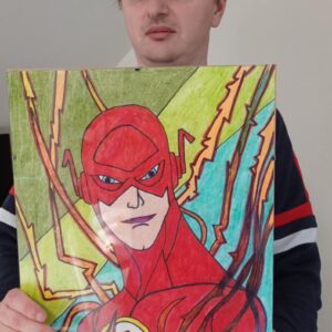 Mężczyzna trzymający kolorowy rysunek superbohatera Flash, wykonany intensywnymi barwami, z widocznymi detalami kostiumu i tłem w odcieniach zieleni i niebieskiego.